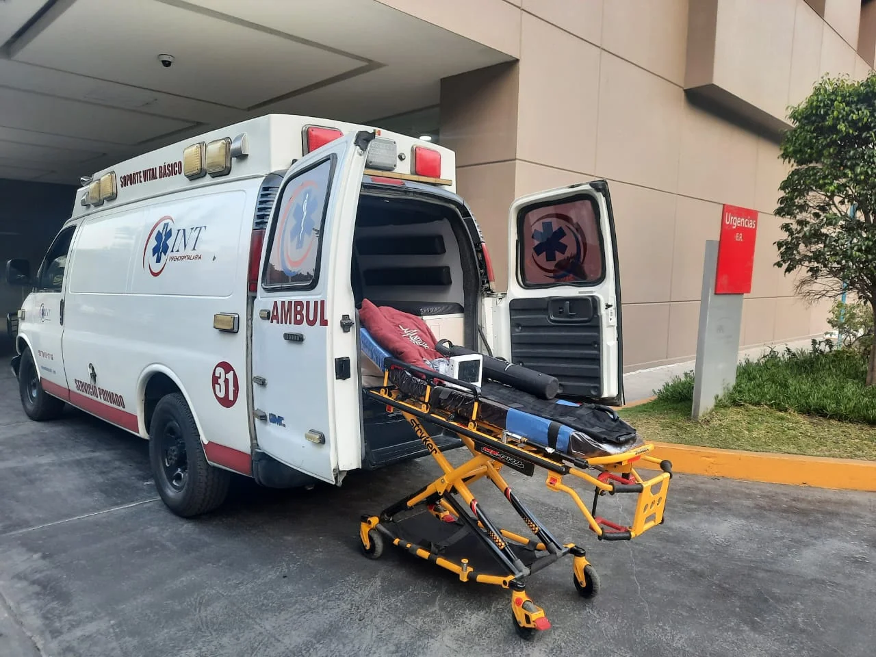 Ambulancia con puertas traseras abiertas y camilla para traslado de paciente