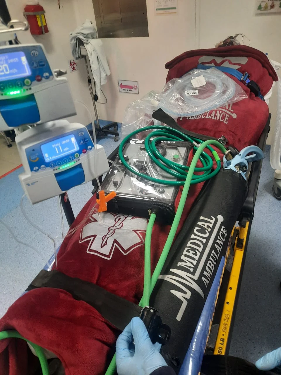 Paciente en camilla con ventilador y oxígeno para traslado de terapia intensiva