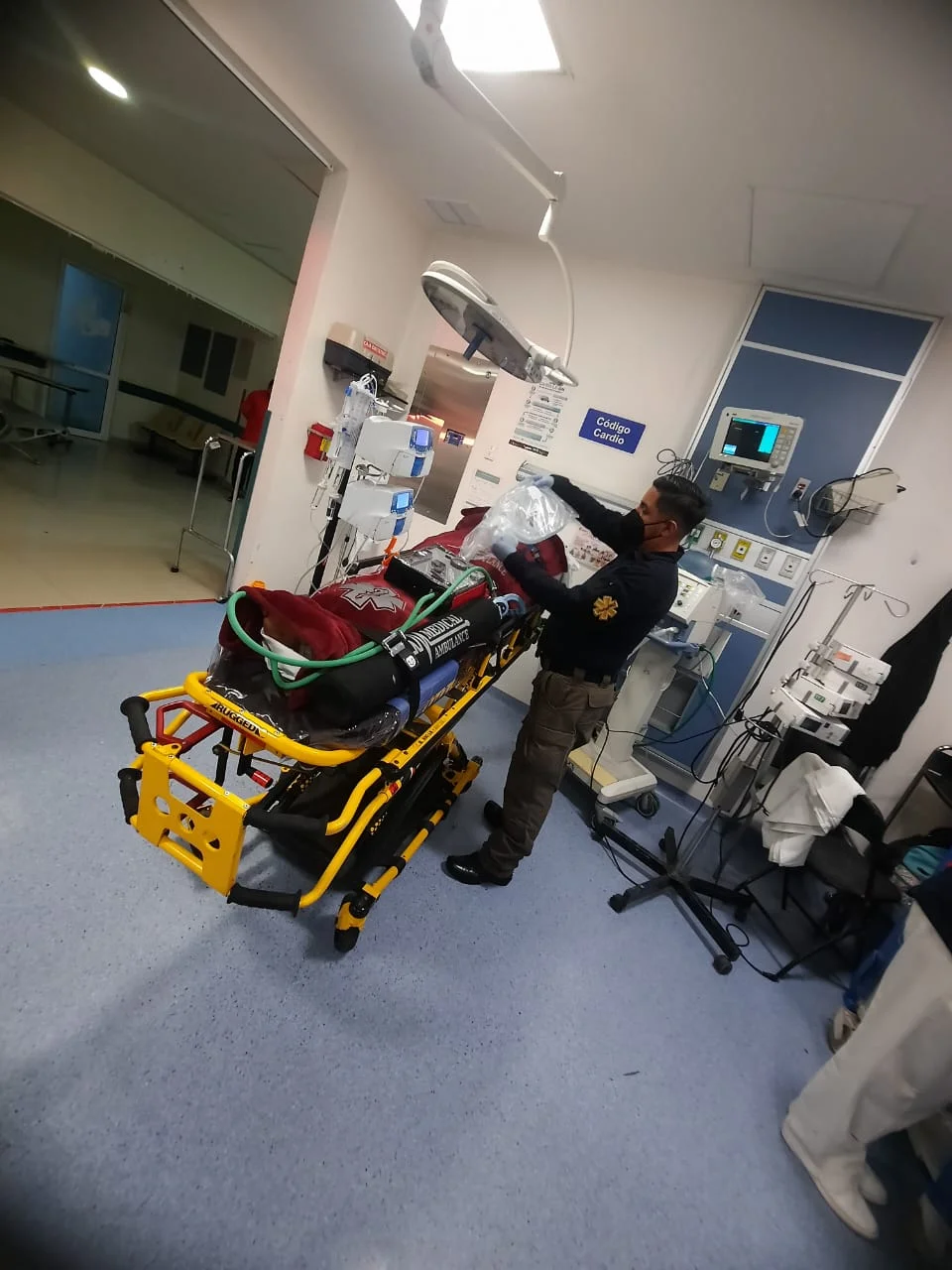 Paramédico preparando traslado de paciente desde área hospitalaria